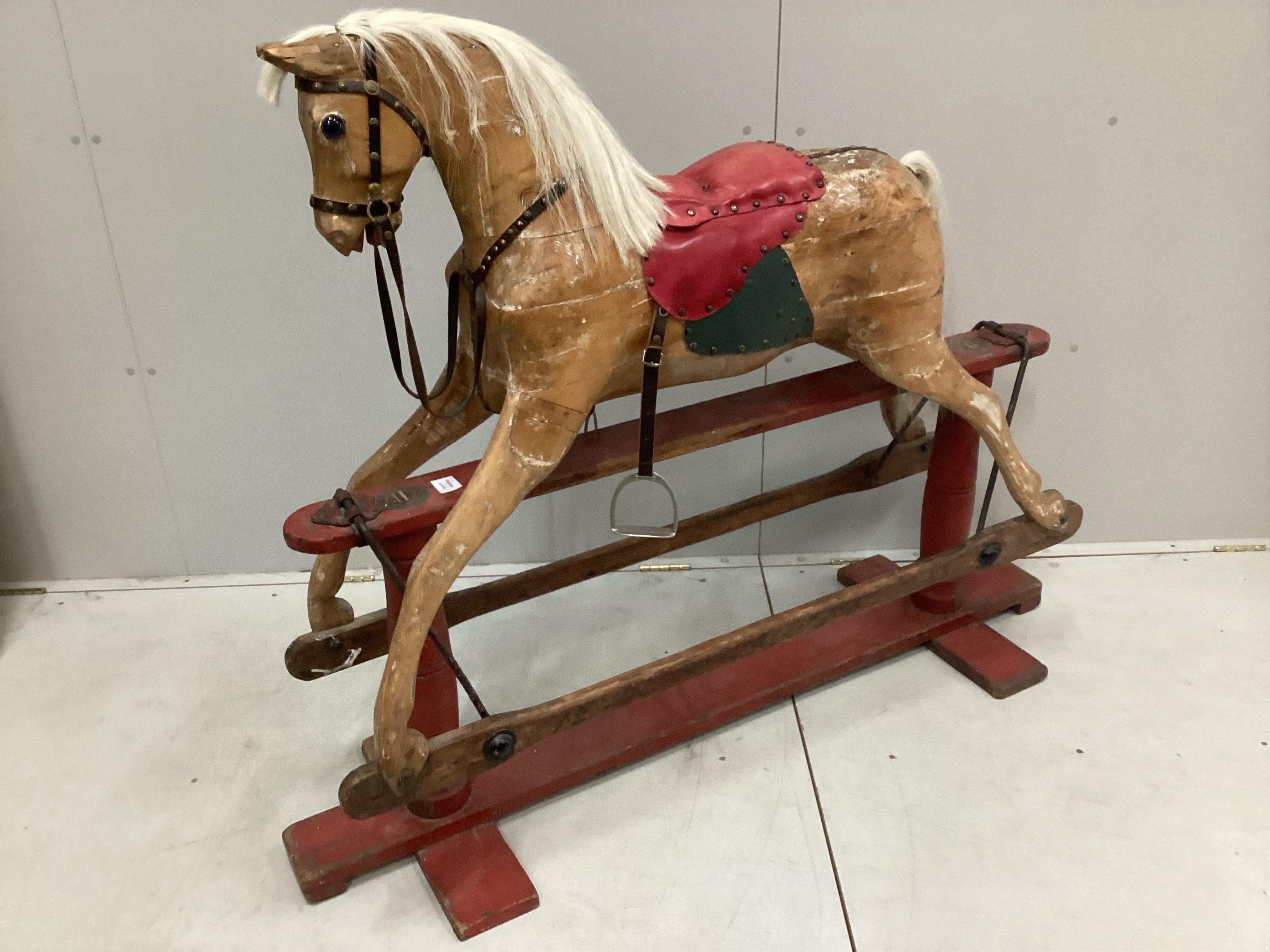 An early 20th century carved wood rocking horse on stand (a.f.), 117cm high, base of stand 146 wide